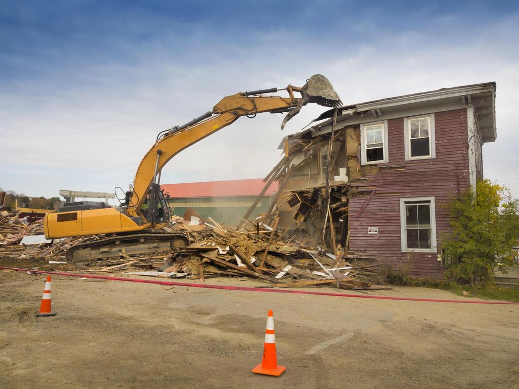 house being demolished using truck